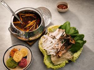 a table with two plates of food and a pot of soup at Lam Stay Grand World Phu Quoc in Phú Quốc +19 photos
