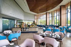 a restaurant with blue chairs and tables and windows at Sunrise Pool Villa Cam Ranh in Cam Ranh