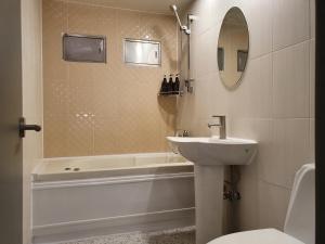 a bathroom with a sink and a tub and a toilet at IM Hotel in Seoul +14 photos