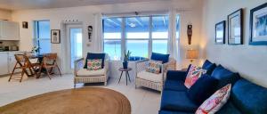 a living room with a blue couch and chairs at Sand Star in Russel Island