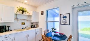 a kitchen with a blue table and a window at Sand Star in Russel Island +9 photos