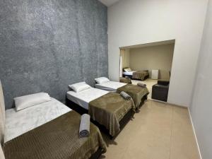 a room with four beds and a couch at Alvorada Hospedagem in Jataí