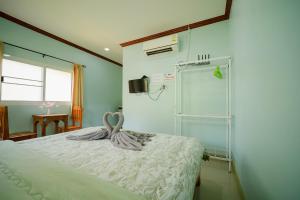 a bedroom with a bed with a towel on it at Baanklongkok in Ban Map Khangkhao