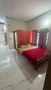 a bedroom with a large bed with a red wall at Vanasiri stay inn in Sringeri