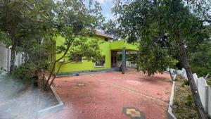 a yellow house with a red brick driveway at Vanasiri stay inn in Sringeri +4 photos