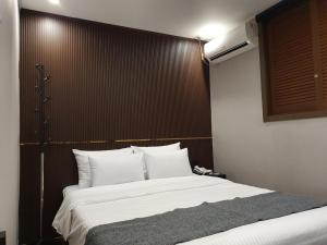 a bedroom with a large bed with a wooden headboard at IM Hotel in Seoul
