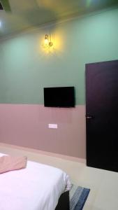 a bedroom with a bed and a tv on the wall at Quiet Corner 4BHK Villa in Lucknow