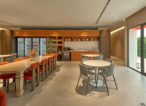 an open kitchen and dining room with tables and chairs at Go Hotel Khon Kaen Campas in Ban Nong Waeng