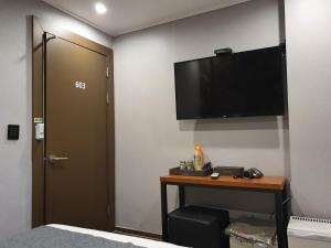 a room with a bed and a television on a wall at IM Hotel in Seoul