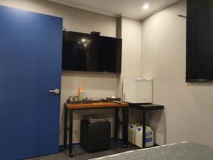a room with a blue door and a desk with a microwave at IM Hotel in Seoul