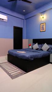 a bedroom with a bed with a blue wall at Quiet Corner 4BHK Villa in Lucknow