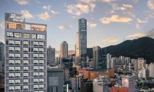 a city skyline with tall buildings and mountains at Archieve 4H hotel Busan in Busan