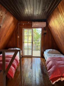 two beds in a room with a window at La Alpina playa Nebel in Concordia