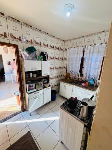 a kitchen with white cabinets and a counter top at Chácara Nunes in Ibiúna +12 photos