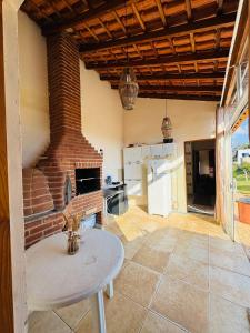 a kitchen with a brick fireplace and a table at Chácara Nunes in Ibiúna