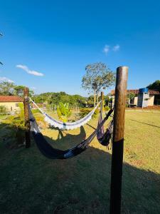 a hammock tied to a wooden pole in a field at Chácara Nunes in Ibiúna