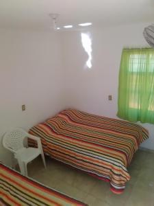 1 cama con manta y silla en una habitación en Hotel Rocio, en Cedral