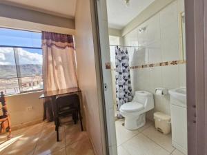 a bathroom with a toilet and a sink with a window at Samaykuy Bed and Breakfast in Urubamba +97 photos