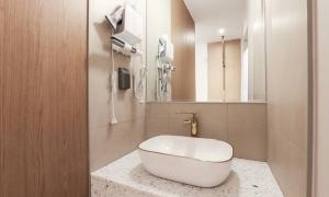 a bathroom with a white tub sitting on a counter at Wonju Brown Dot Hotel Corporate city in Wonju