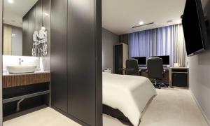 a hotel room with a bed and a sink at Wonju Brown Dot Hotel Corporate city in Wonju