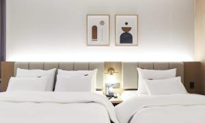 two beds in a hotel room with white sheets at Wonju Brown Dot Hotel Corporate city in Wonju +50 photos