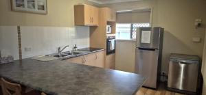 a kitchen with a sink and a refrigerator at Little Sanctuary by Book Jervis Bay - Your Perfect Getaway, A Short Stroll to Palm Beach in Sanctuary Point