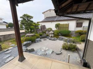 an asian garden with rocks and a building at Yoike Stay in Yonago