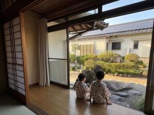 two children sitting in front of a sliding glass door at Yoike Stay in Yonago +34 photos