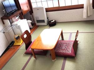 a room with a table and chairs in a room at 湯畑源泉宮崎館 in Kusatsu