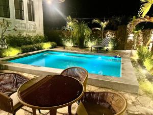 a swimming pool with chairs and a table next to it at Casa Katipunan in Manila