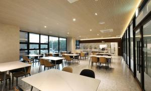 a restaurant with tables and chairs and a kitchen at Pohang Hound Hotel Songdo Beach in Pohang