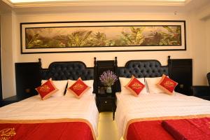 a hotel room with two beds with red and white pillows at Nhật Long Hotel in Giap Ninh Binh