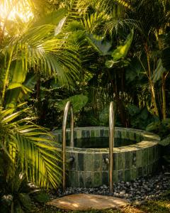a stone tub in the middle of a garden at Loku Kedungu - Boutique Resort in Tanah Lot