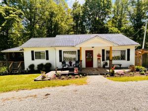 a small white house with a porch at North Star Retreats in Beattyville