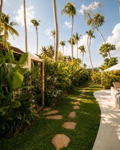 a path leading to a resort with palm trees at Loku Kedungu - Boutique Resort in Tanah Lot