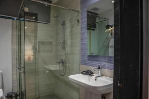 a bathroom with a sink and a glass shower at Casa Katipunan in Manila +9 photos