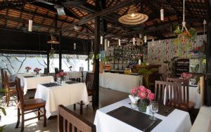 a restaurant with white tables and chairs and flowers at Harmony Hotel in Siem Reap
