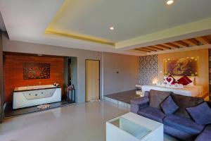 a living room with a couch and a bed at Sita Beach Resort in Ko Lipe