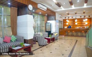 a lobby with a waiting area with chairs and a clock at Ascott The Residence - Baridhara, Dhaka in Dhaka