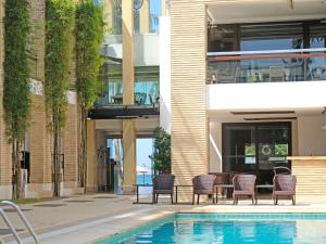 a swimming pool with chairs and a table next to a building at The District Boracay in Boracay +12 photos