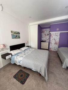 a bedroom with a large bed and purple walls at Josefina l in Goya