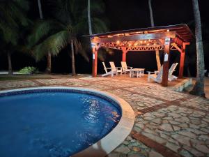 a swimming pool with a gazebo and a table and chairs at Nice View always available in Juan Dolio