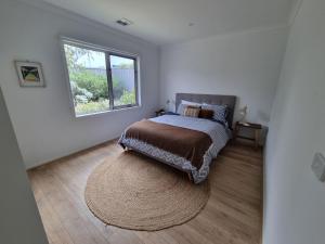 a bedroom with a bed and a large window at Adagio at Lonsdale in Point Lonsdale