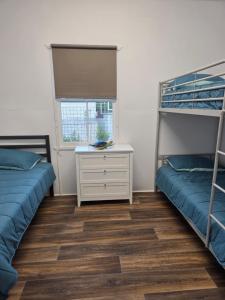 a bedroom with two bunk beds and a desk at The Crab Shack in Boonooroo