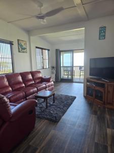 a living room with a couch and a flat screen tv at The Crab Shack in Boonooroo