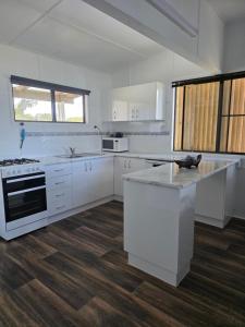 a kitchen with white cabinets and a counter top at The Crab Shack in Boonooroo