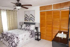 a bedroom with a bed and a ceiling fan at Oceanview Retreat - 3 bedroom in Bull Bay