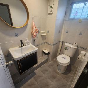 a bathroom with a toilet and a sink and a mirror at The Layover Donmueang Airport Hostel in Thung Si Kan