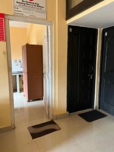 a room with a black door and a refrigerator at SOMNATH Share House in Queula