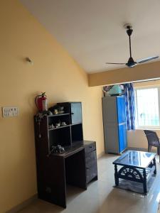a living room with a desk and a table at SOMNATH Share House in Queula